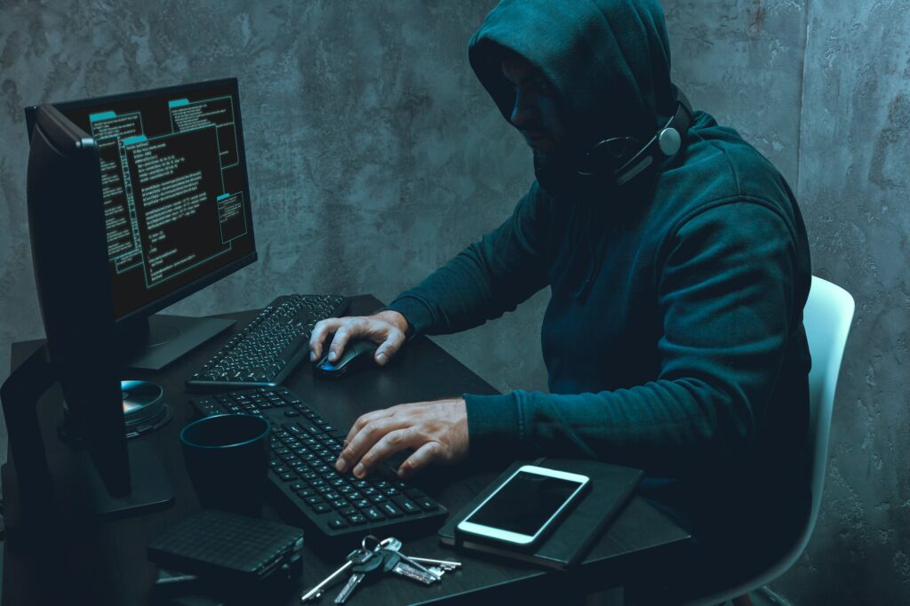 Hacker programmer using computer in dark room